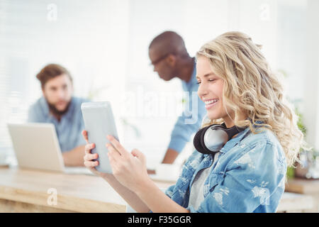 Side view of smiling woman with headphones while using digital tablet Stock Photo