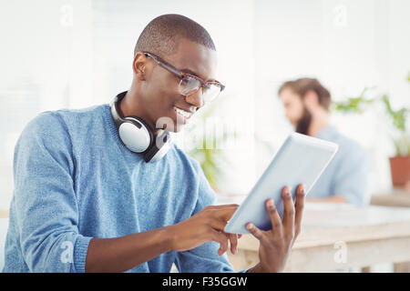 Smiling man with headphones while using digital tablet Stock Photo