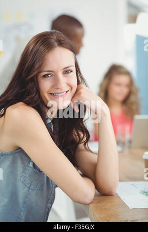 Portrait of smiling woman sitting at desk Stock Photo