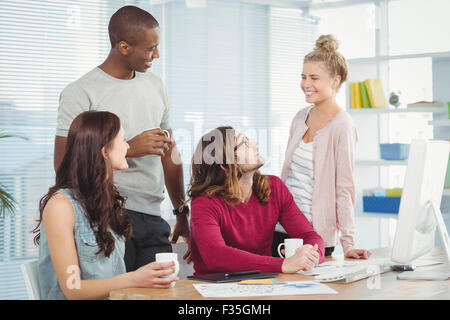 Smiling business team at computer desk Stock Photo