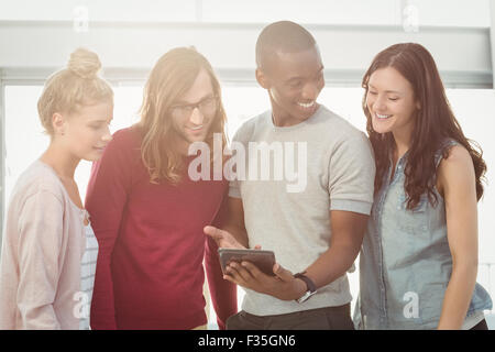 Smiling man showing digital tablet to coworkers Stock Photo