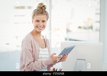 Portrait of smiling woman using digital tablet in office Stock Photo