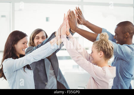 Smiling business team giving high five Stock Photo