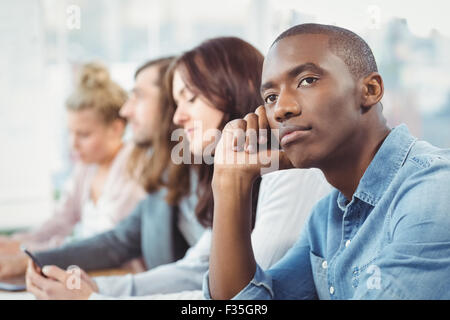Thoughtful man sitting at desk Stock Photo