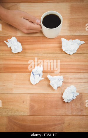 Businessman holding black coffee cup on desk Stock Photo