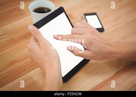 Man using digital tablet at desk in office Stock Photo