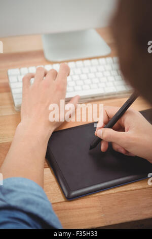 Businessman using graphics tablet on desk in office Stock Photo