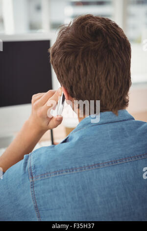 Businessman using mobile phone at desk in office Stock Photo