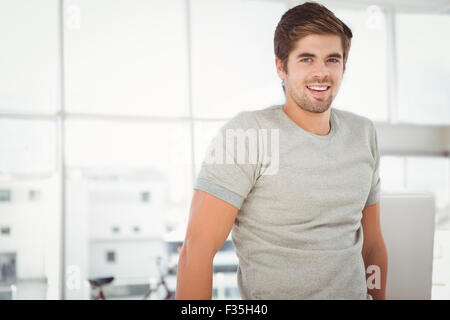 Businessman smiling while standing against window Stock Photo
