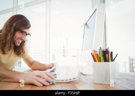 Hipster smiling while looking at documents Stock Photo
