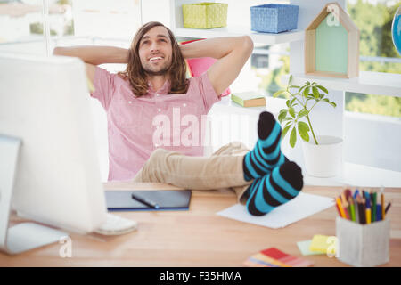 Hipster relaxing with legs on desk Stock Photo