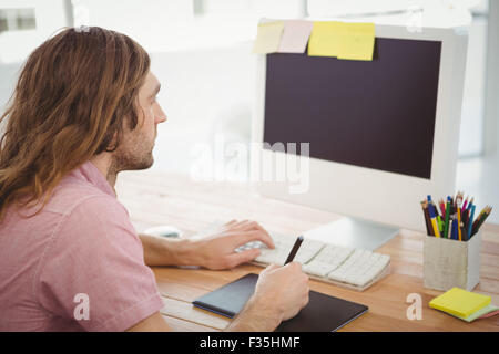 Man working on computer with graphics tablet Stock Photo