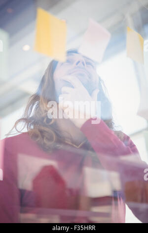Low angle view of thoughtful businessman looking at sticky note Stock Photo
