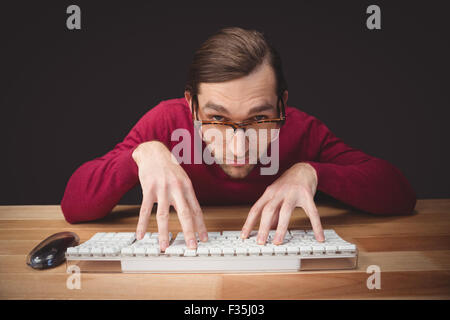 Man wearing eye glasses typing on computer keyboard Stock Photo