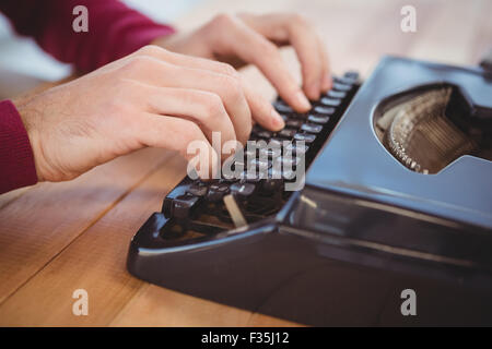 Cropped image of man typing on typewriter at desk Stock Photo