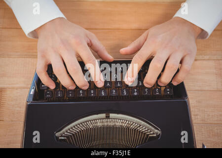 Man working on typewriter at table in office Stock Photo