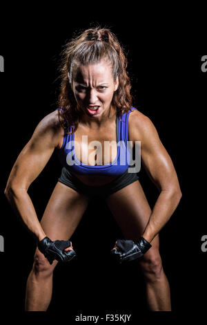 Portrait of aggressive female boxer flexing muscles Stock Photo