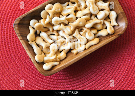 Small salty crackers in shape of fish lay in a wooden bowl on the table. Selective focus with shallow DOF Stock Photo