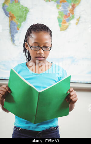 Focused pupil reading book in a classroom Stock Photo