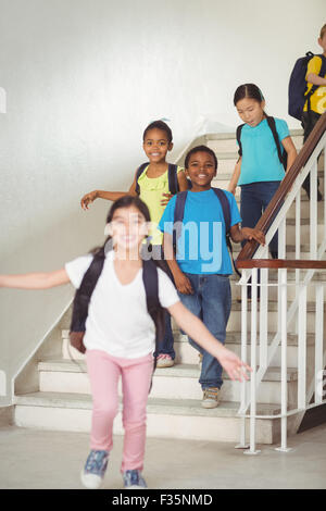 Happy pupils walking down the stairs Stock Photo