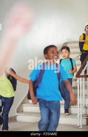 Happy pupils walking down the stairs Stock Photo