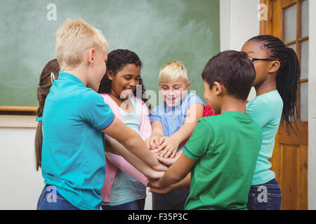 Students putting hands together Stock Photo - Alamy