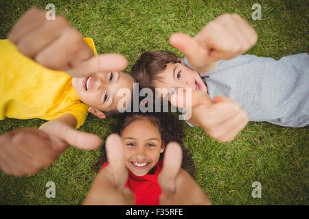 Cute pupils lying on grass smiling Stock Photo