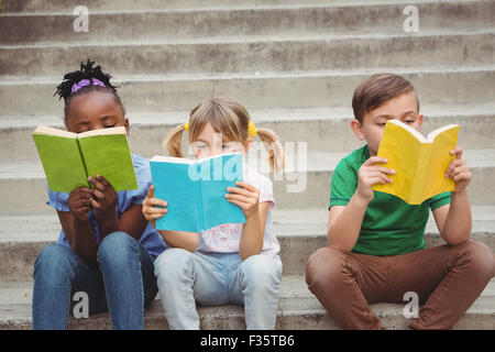 Students sitting on steps and reading books Stock Photo