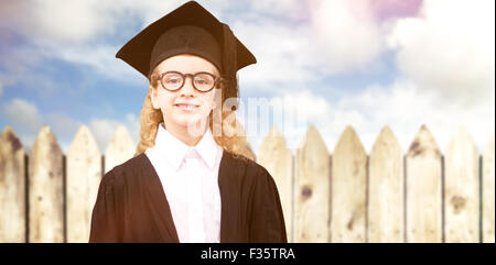 Composite image of cute pupil in graduation robe Stock Photo