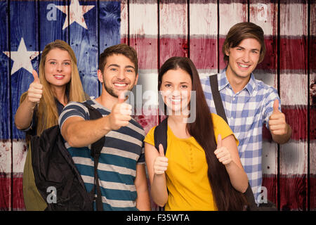 Composite image of happy students gesturing thumbs up at college corridor Stock Photo