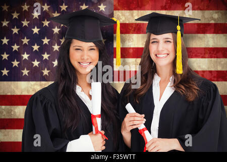 Composite image of two friends stand together after graduating Stock Photo
