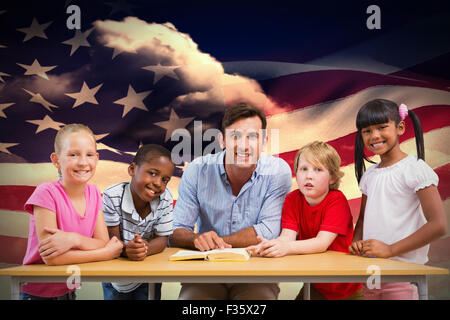 Composite image of teacher and pupils smiling at camera at library Stock Photo