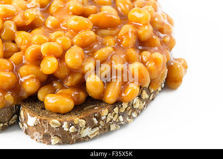 Beans on toast. Selective focus on beans placed on grain toast with a white background leaving room for copy space and text Stock Photo