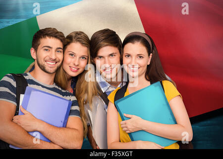 Composite image of happy students holding folders at college corridor Stock Photo