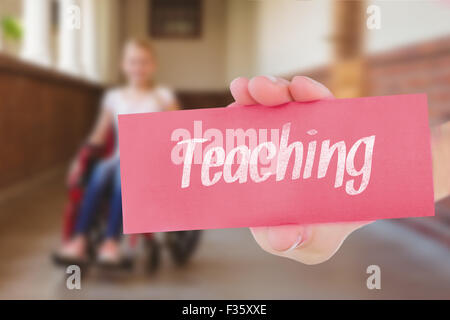 Teaching against cute pupils writing at desk in library Stock Photo