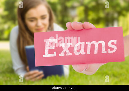 Exams against university student lying and using tablet pc Stock Photo