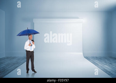 Composite image of happy businessman holding umbrella Stock Photo