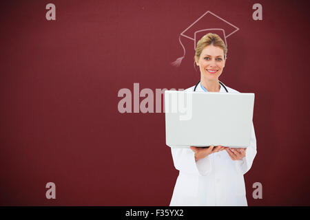 Composite image of blonde doctor using laptop Stock Photo