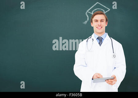 Composite image of young doctor using tablet pc Stock Photo