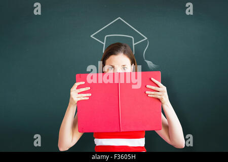 Composite image of student holding book over face Stock Photo