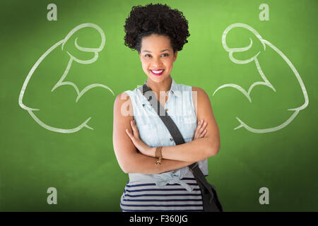 Composite image of portrait of casual young woman standing with arms crossed Stock Photo