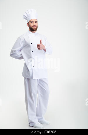 Full length portrait of a handsome male chef cook showing thumb up sign isolated on a white background Stock Photo