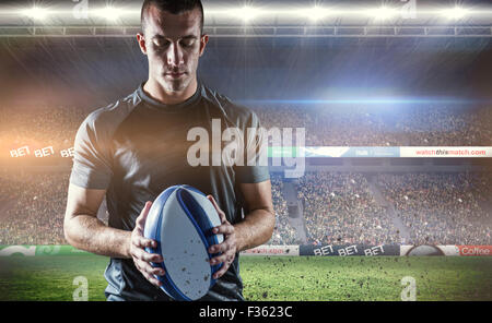Composite image of thoughtful rugby player holding ball Stock Photo