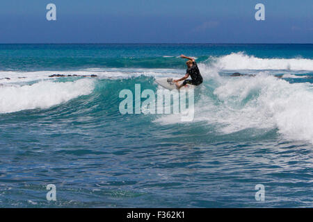 A surfer riding the waves at Kanahena Beach, Maui, Hawaii in July Stock Photo