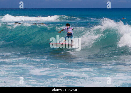 A surfer riding the waves at Kanahena Beach, Maui, Hawaii in July Stock Photo