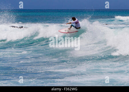 A surfer riding the waves at Kanahena Beach, Maui, Hawaii in July Stock Photo