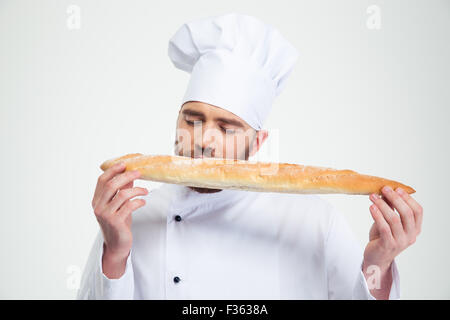 Portrait of a male chef cook smelling fresh bread against white background Stock Photo