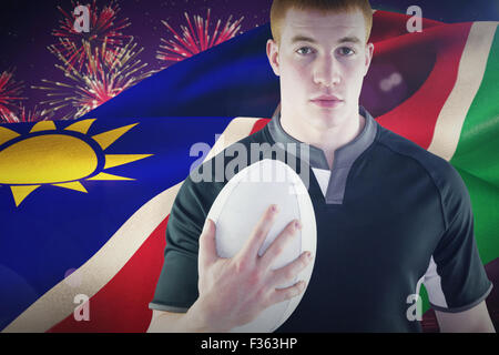 Composite image of rugby player holding a rugby ball Stock Photo