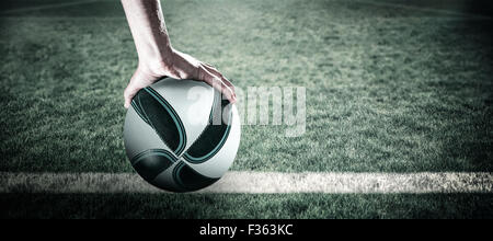 Composite image of rugby player with arm raised holding ball Stock Photo