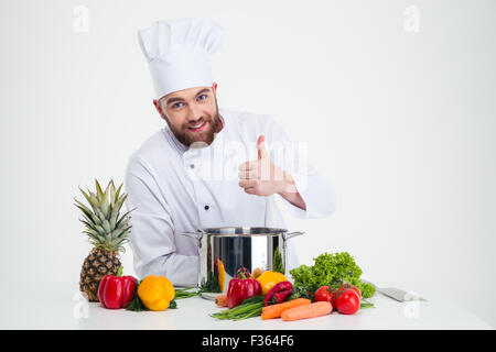 Portrait of a happy male chef cook preparing food and showing thumb up isolated on a white background Stock Photo